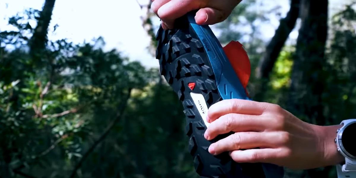 Vue rapprochée de la semelle extérieure d'une chaussure de trail avec crampons profonds